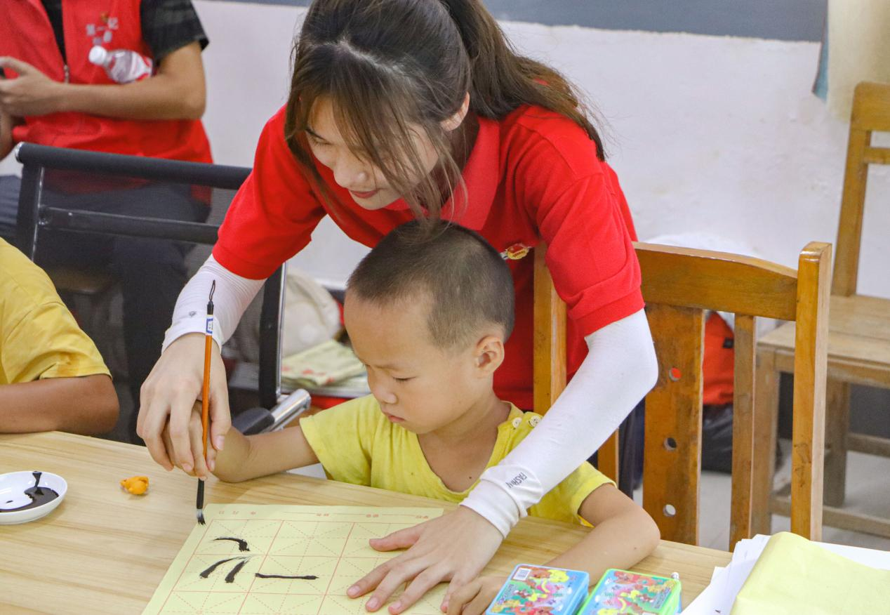 觀察團(tuán)成員指導(dǎo)小朋友書法